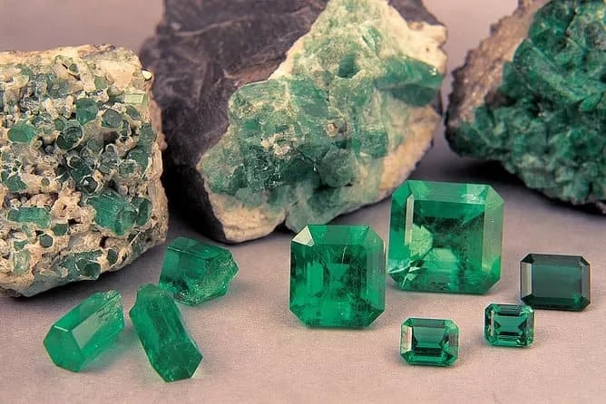 Rough and polished green Colombian emeralds displayed for sale during an exclusive private shopping tour.
