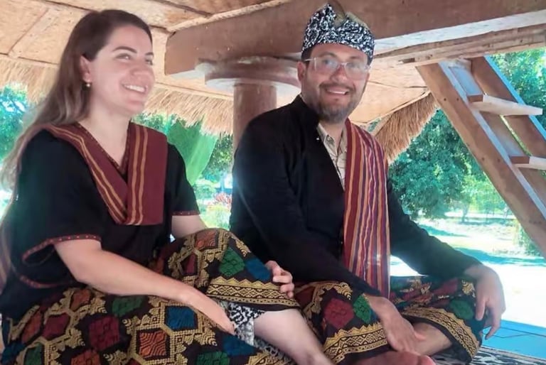 a man and woman sitting on a couch using Tradisional Suku Sasak clothes