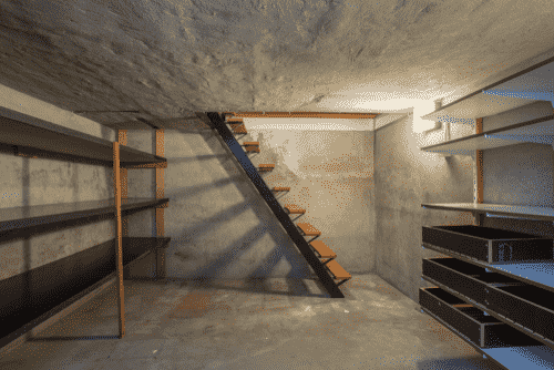 a staircase leading to a basement with a staircase leading up to a second floor