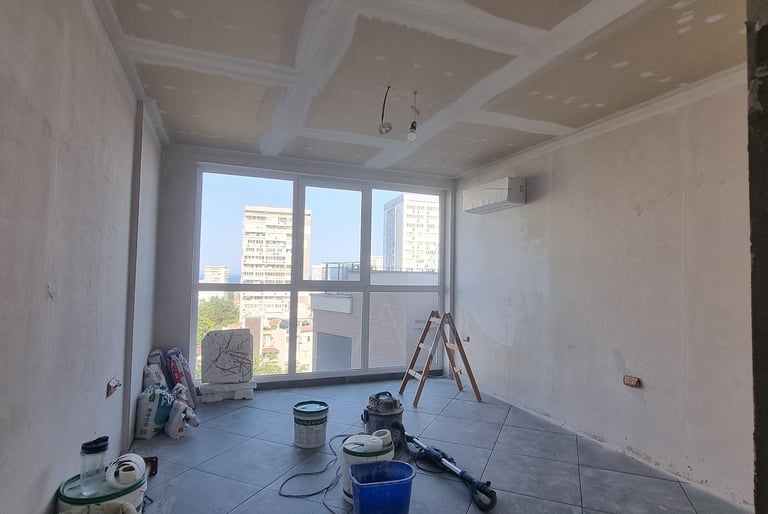 a room with a large window and a bucket of paint