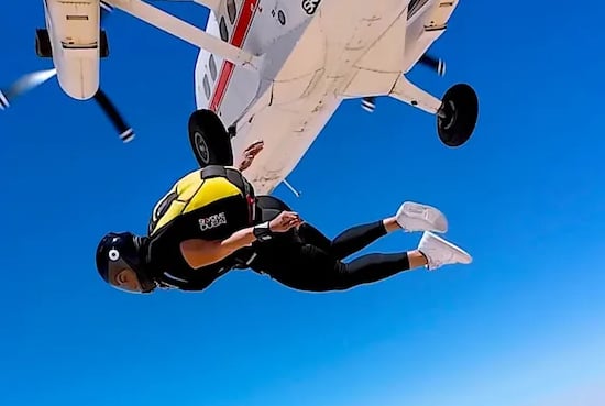 mais alhajri skydiving in yellow and black jumpsuit after jumping from a plane
