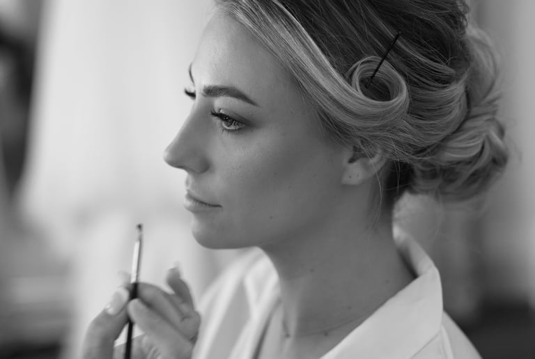 a woman getting makeup done by a professional makeup artist