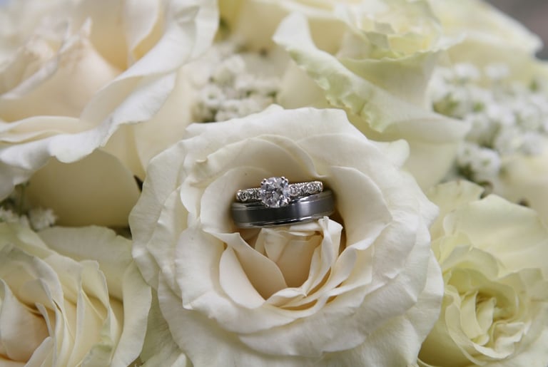 Wedding rings on a Bride's Bouquet of White Roses