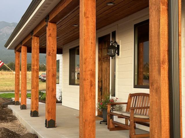 Wood beams and cement patio of custom home in Montana with mountains