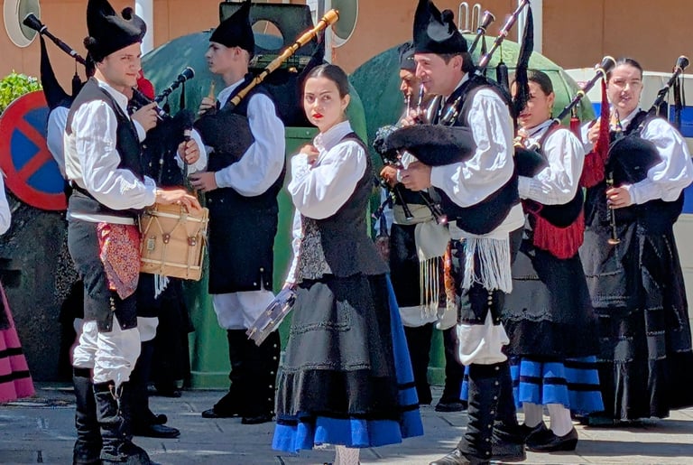 a group of people in traditional Galician clothing with gaitas gallegas, drums and panderetas