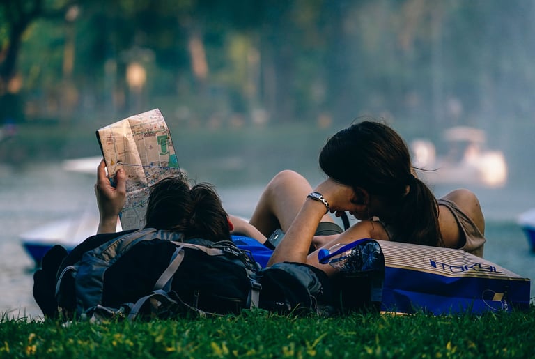 a woman reading a book while sitting on a bench