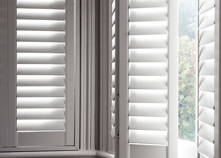 picture of a bay window with hardwood shutters