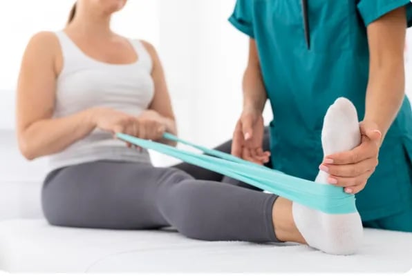 Terapeuta en Quiropraxia dando atención correctiva inicial a paciente en pierna y pie derecho