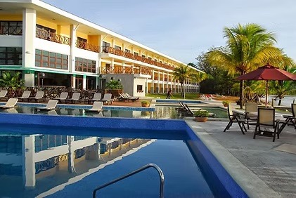 a pool with chairs and umbrellas in front of a building