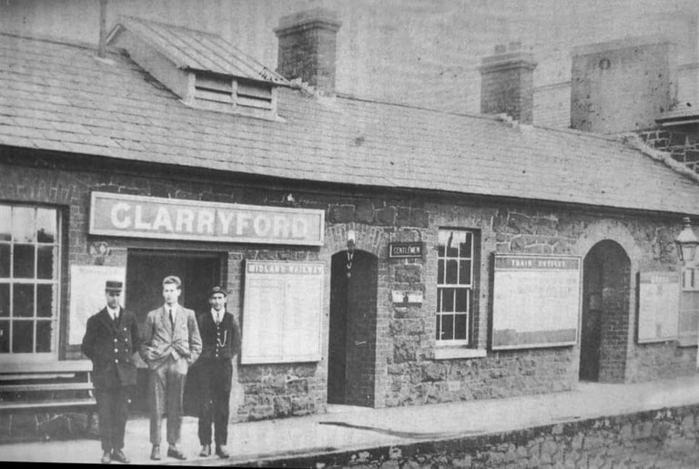 An old black and white picture of Glarryford Train Station. There are three men standing out front. 