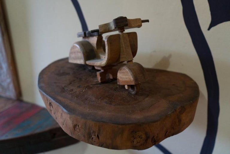 деревянный скутер Vespa, стоящий на деревянном столе в Sunrise Londge and Lounge Art, Ловина, Бали