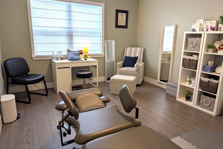 Professional pelvic floor physical therapy clinic room with a treatment table, desk, and cozy seating.