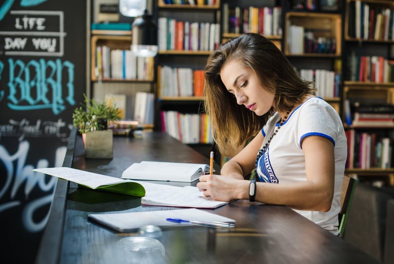 Autora trabajando en su obra en una biblioteca, imagen representativa de autores y editoriales