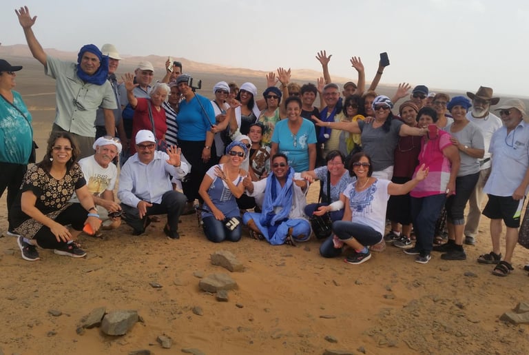 Grupo de turistas brasileiros no Deserto do Saara, passeio de camelo e aventura em Marrocos, turismo