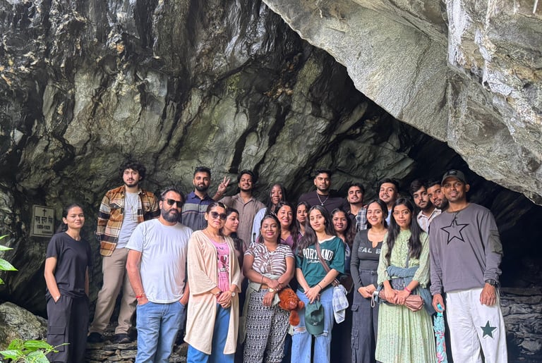 a group of people standing in front of a cave