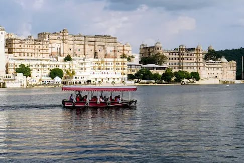 Boat ride on Lake Pichhola with City Palace Udaipur in the background.