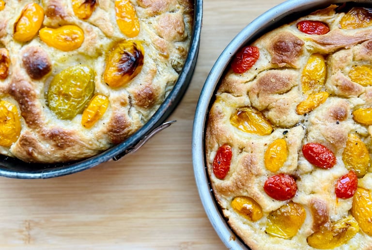 focaccia baked and presented on the mold with market tomatoes