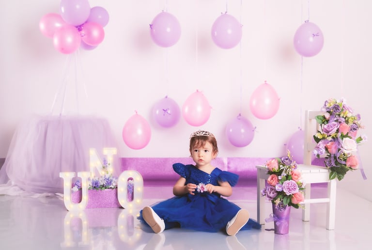 a little girl in a purple dress sitting on a couch