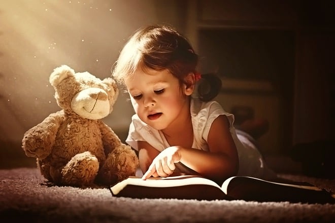Young girl reading book with toy bear posing for a studio photography portrait