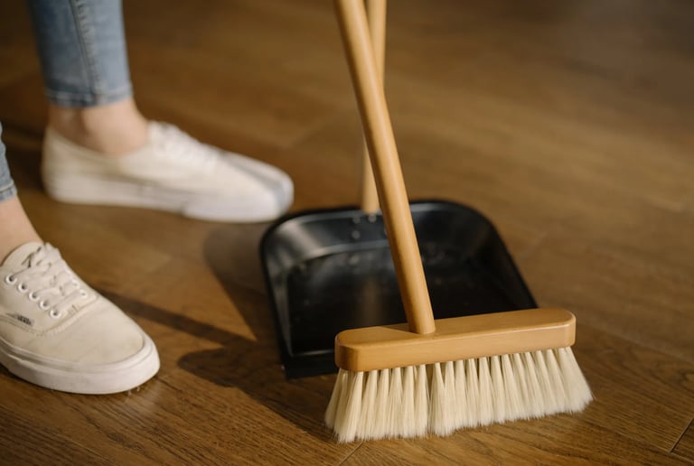 a person standing on a wooden floor with a broom and a broom