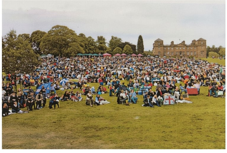 Crowds sitting on a lawn during for first Romany Wood performance at Hagley Hall