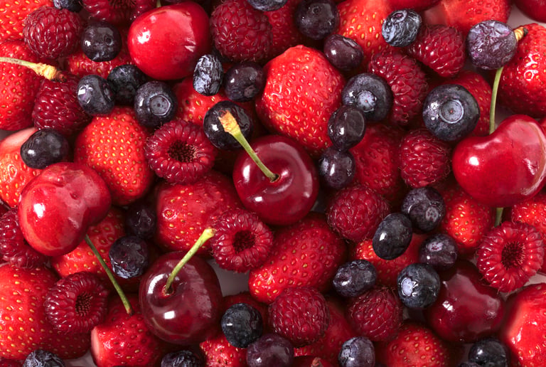 A vibrant assortment of fresh mixed berries including ripe strawberries, blueberries, raspberries, and sweet red cherries.