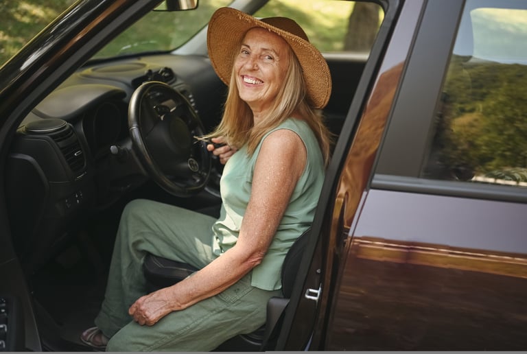 Mujer mayor sonriendo mientras se sube a su coche, reflejando independencia y autonomía en la tercer
