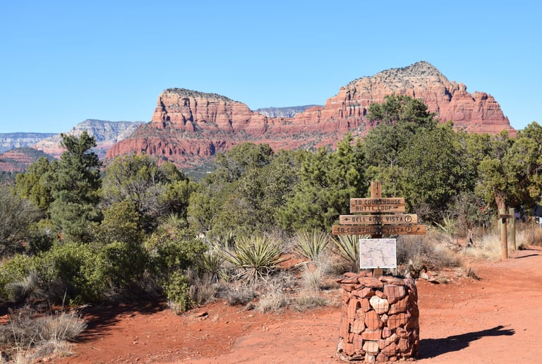 Trail head crossroads wooden marker with red rock Sedona mountain background