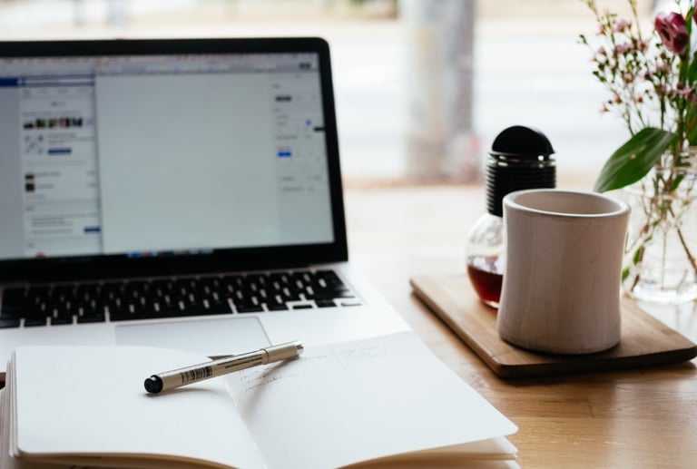 a laptop computer and a pen on a desk