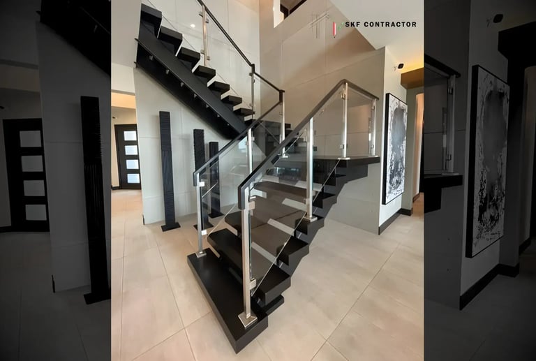 Modern floating staircase with black wood steps and a sleek glass railing system in a luxury home.