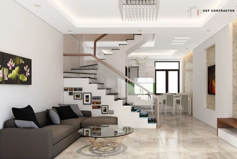 Modern open-concept living room with a dark grey sectional sofa and a sleek white staircase with glass railings.