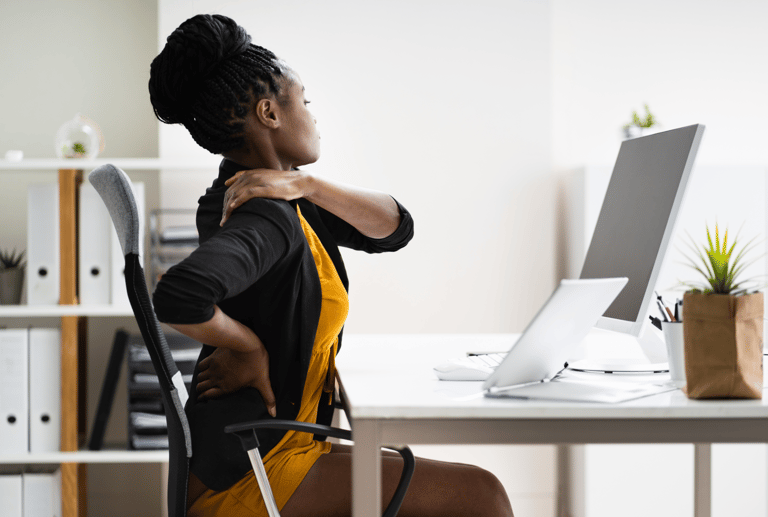 A black lady experiencing back pain due to poor Ergonomics
