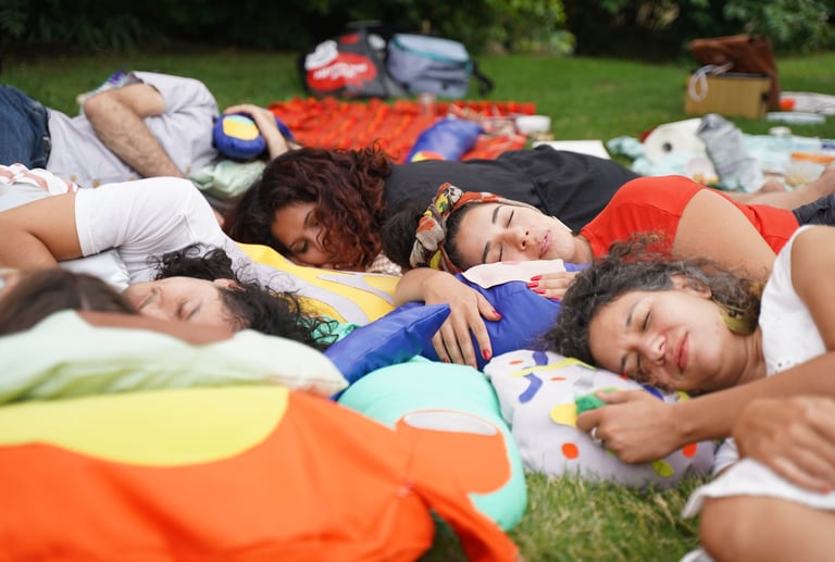 People rest on soft sculptures of body parts.