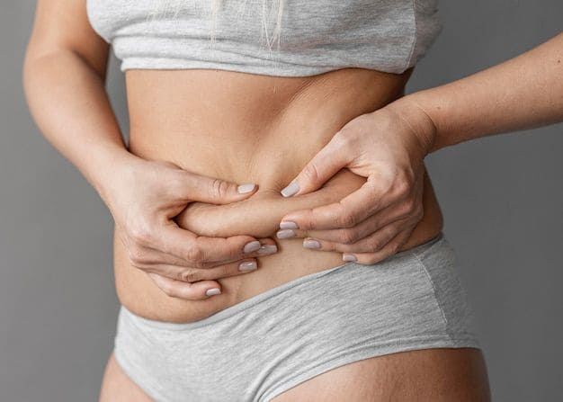 Mujer tomando grasa localizada en el abdomen