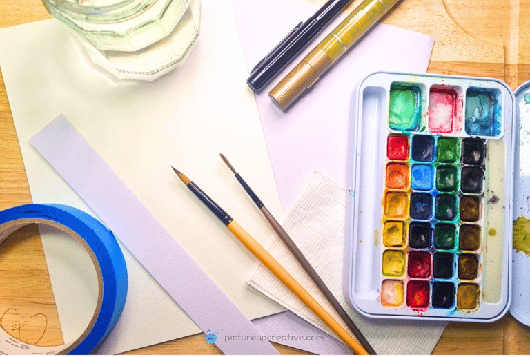 pictureup watercolour materials, colour palette, brushes, water jar, tape, paper, goldpen, fineliner