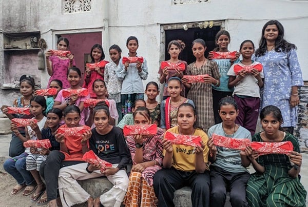 Schoolgirls holding up a Hanaru reusable sanitary napkin