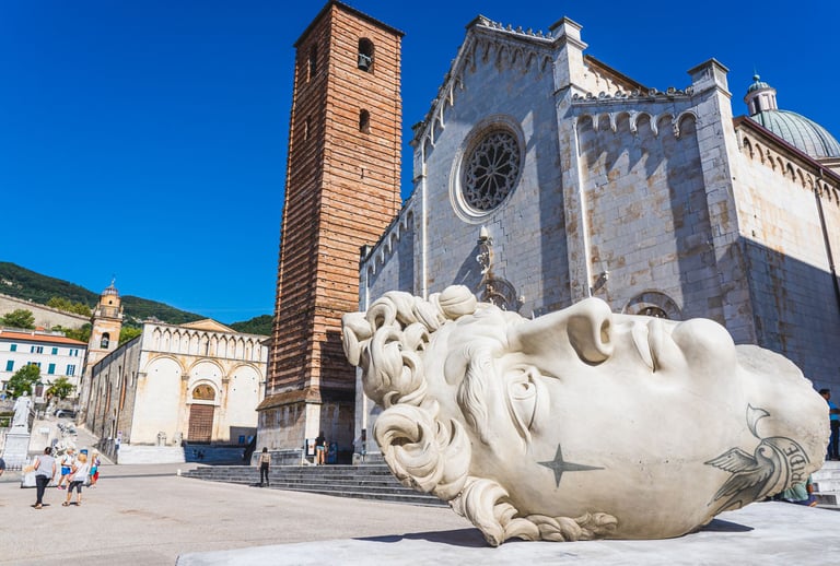 Giant marble head sculpture in Piazza Duomo Pietrasanta Tuscany.