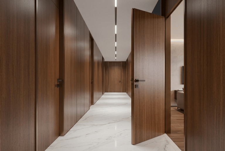 Modern long hallway featuring dark wood paneling, marble flooring, and integrated linear LED ceiling lighting.