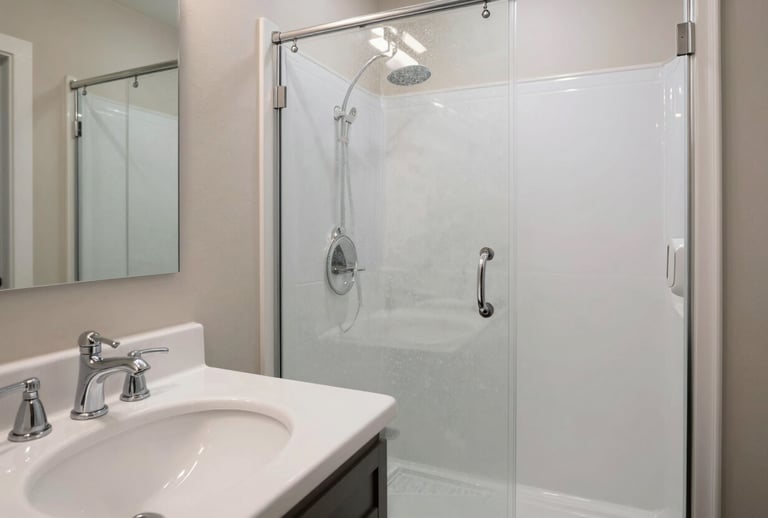 A pristine bathroom in a US suburban home, featuring white porcelain, polished chrome fixtures, and a glass shower door with no water spots, emphasizing professional attention to detail.