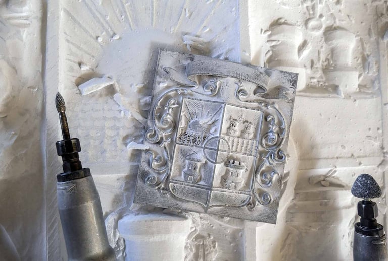 Hand-carved stone family crest plaque being detailed with rotary power engraving tools.
