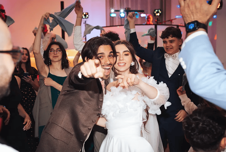Les mariés souriants et complices sur la piste de danse, entourés de leurs invités.