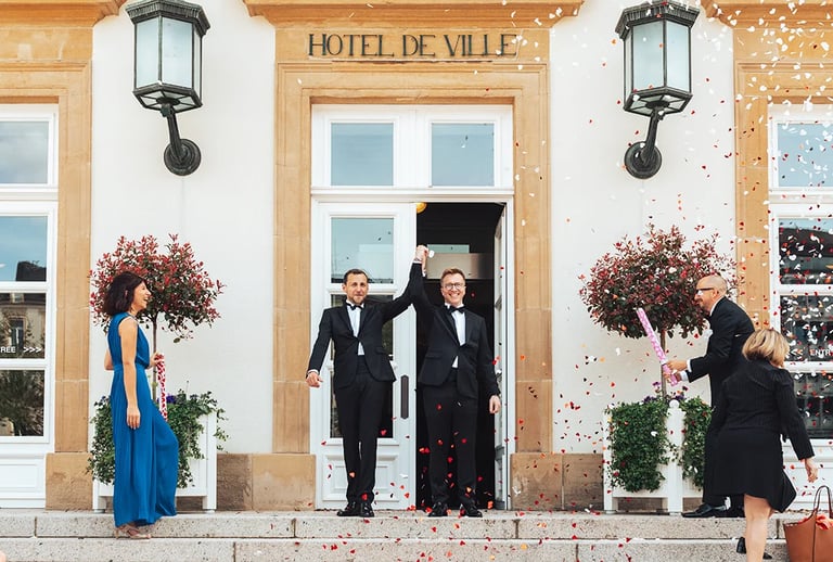 Sortie de mairie des mariés à Luxembourg sous une pluie de confettis, entourés de leurs proches.