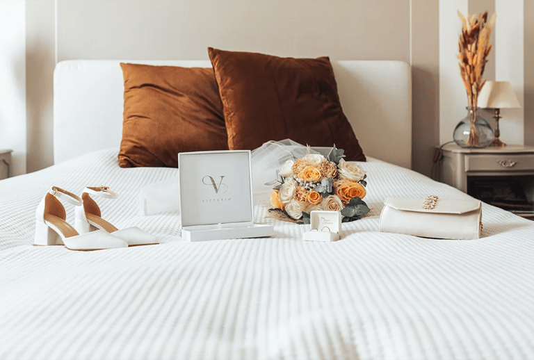 Accessoires de la mariée disposés sur un lit avant les préparatifs du mariage.