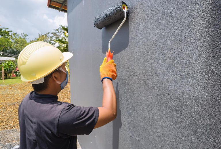 Painter painting exterior wall of Auckland home