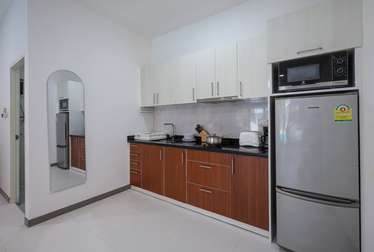Kitchen with large fridge, hob, and microwave.
