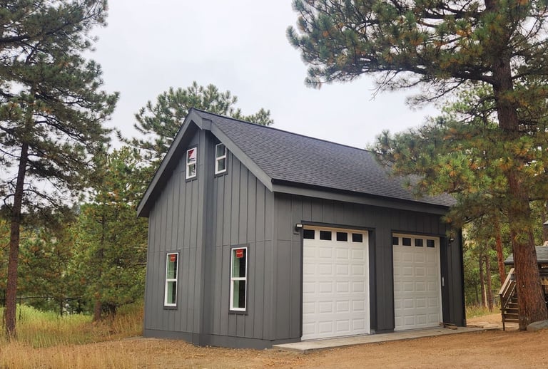 Side profile of a custom mountain garage with dark vertical siding.