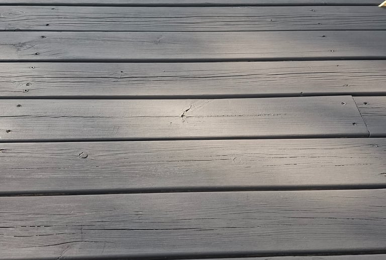 Close-up of matte black natural wood finish on exterior siding showing wood texture