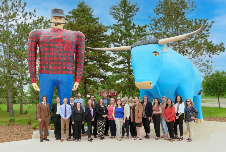 a group of people standing in front of Paul & Babe in Bemidji