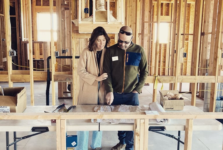 a man and woman standing in a house under construction