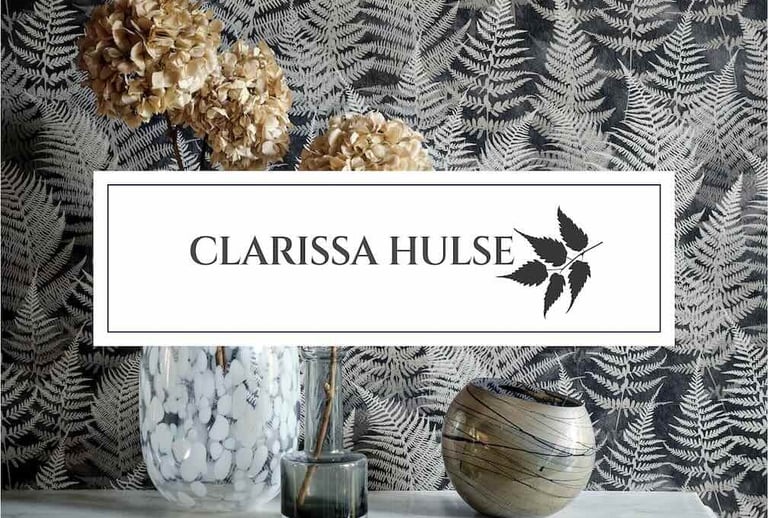 Clarissa Hulse fern wallpaper behind a marble mantel with dried hydrangeas and decorative glass vases.